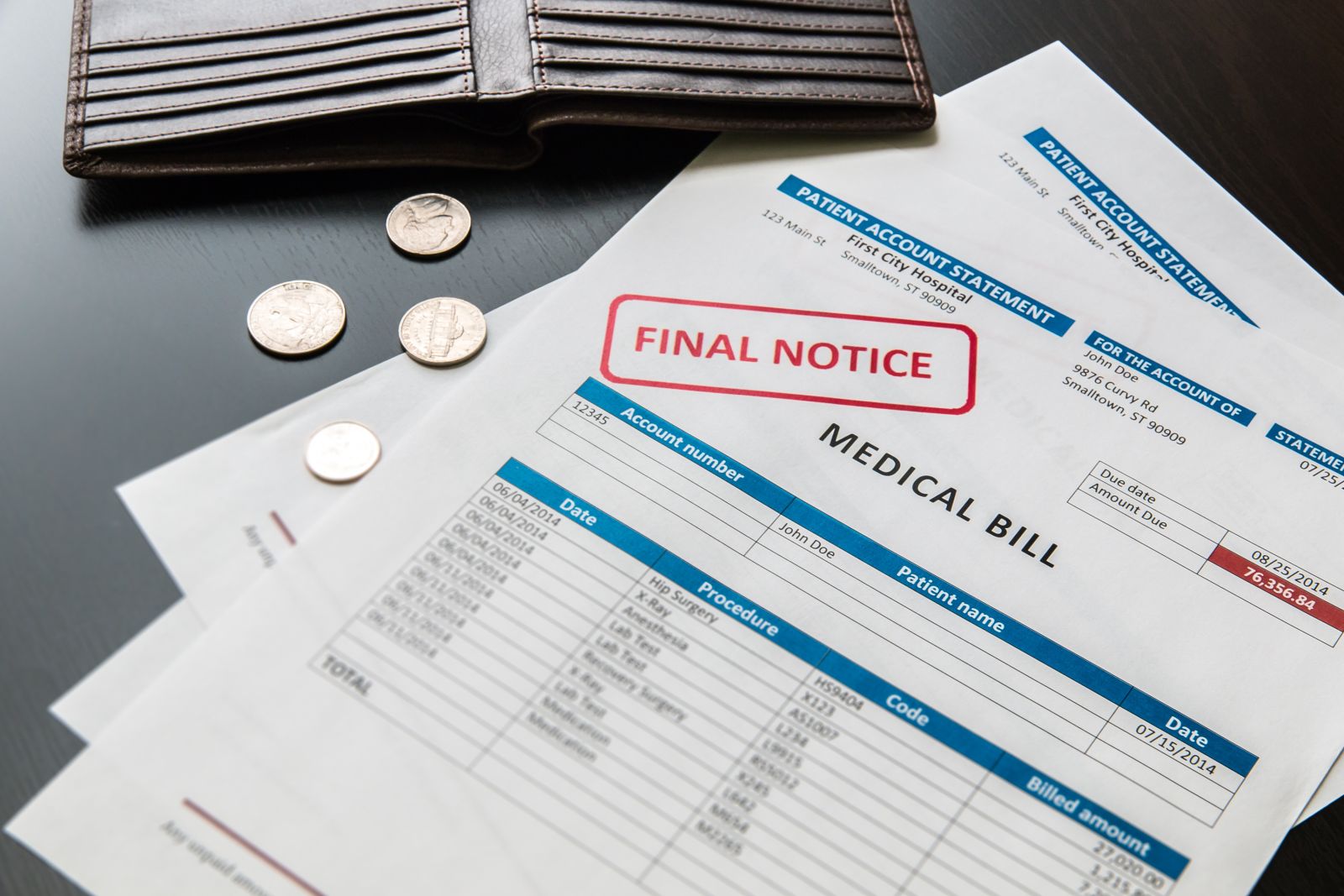 A pile of medical bills with an open wallet by volgariver via Adobe Stock